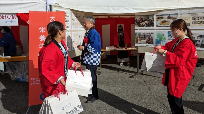 門真市長 宮本一孝様が本学展示ブースをご覧いただきました。