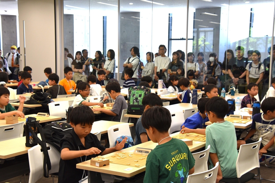 保護者が見守る中、対局する子どもたち