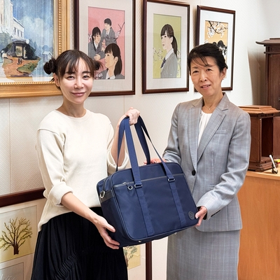 完成したスクールバッグを手にする山口 絵理子代表(左)と松井 真佐美校長(右) 写真=Copyright 2025 MOTHERHOUSE Co.,Ltd.