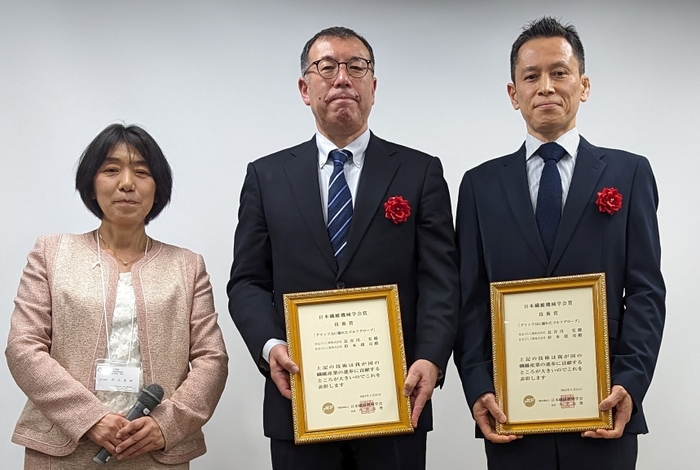 写真左から  日本繊維機械学会長（授賞式当時）神戸大学大学院 井上真理教授 、 当社 スポーツ事業本部 商品開発部 杉本靖司、長谷川宏