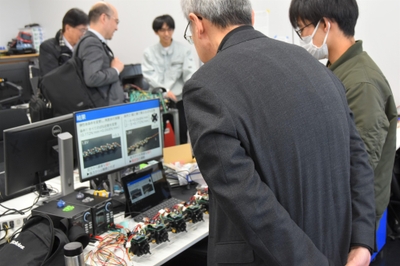 池本研究室の学生一人ひとりが実際のロボットを展示し、その動きを動画で説明