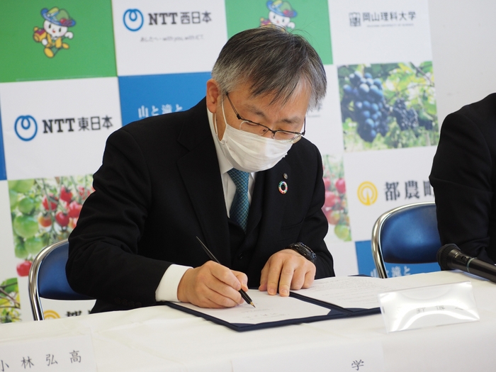 協定書に署名する平野学長