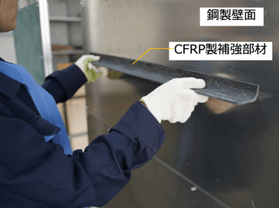 補強部材を壁面に接着している様子*(写真の試験体は本公開実験と異なります)