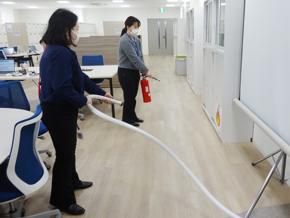 モバイルバッテリー火災を想定した消火訓練を行う医誠会国際総合病院の職員(大阪市北区)