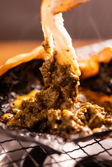 焼きガニをカニ味噌につけて食す