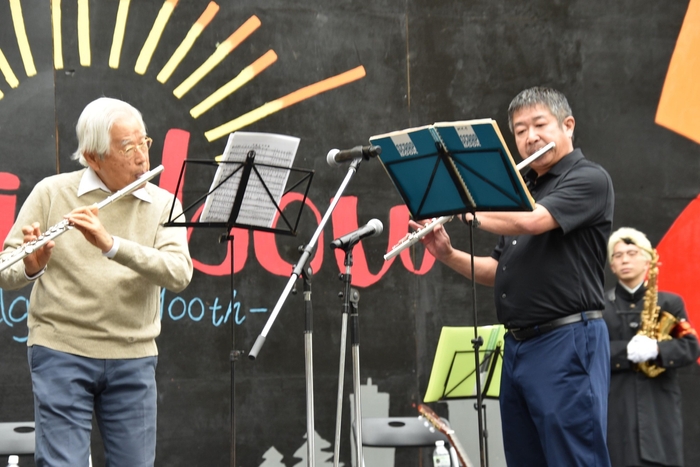 フルート演奏を披露する飯島終身教授(左)
