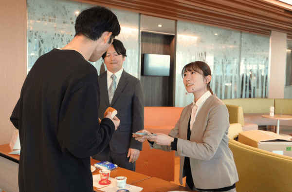 試食を行う肥後銀行職員（左）と説明をしているトイメディカル社員（右）