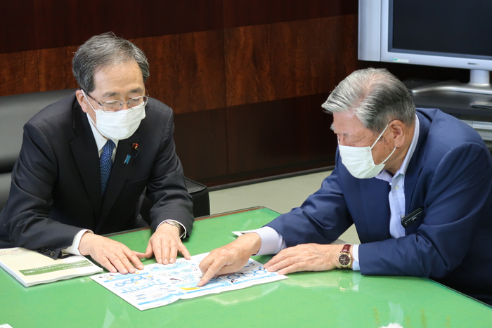 提言書内容を図解したイラストを前に意見交換を行う斉藤大臣と谷口会長