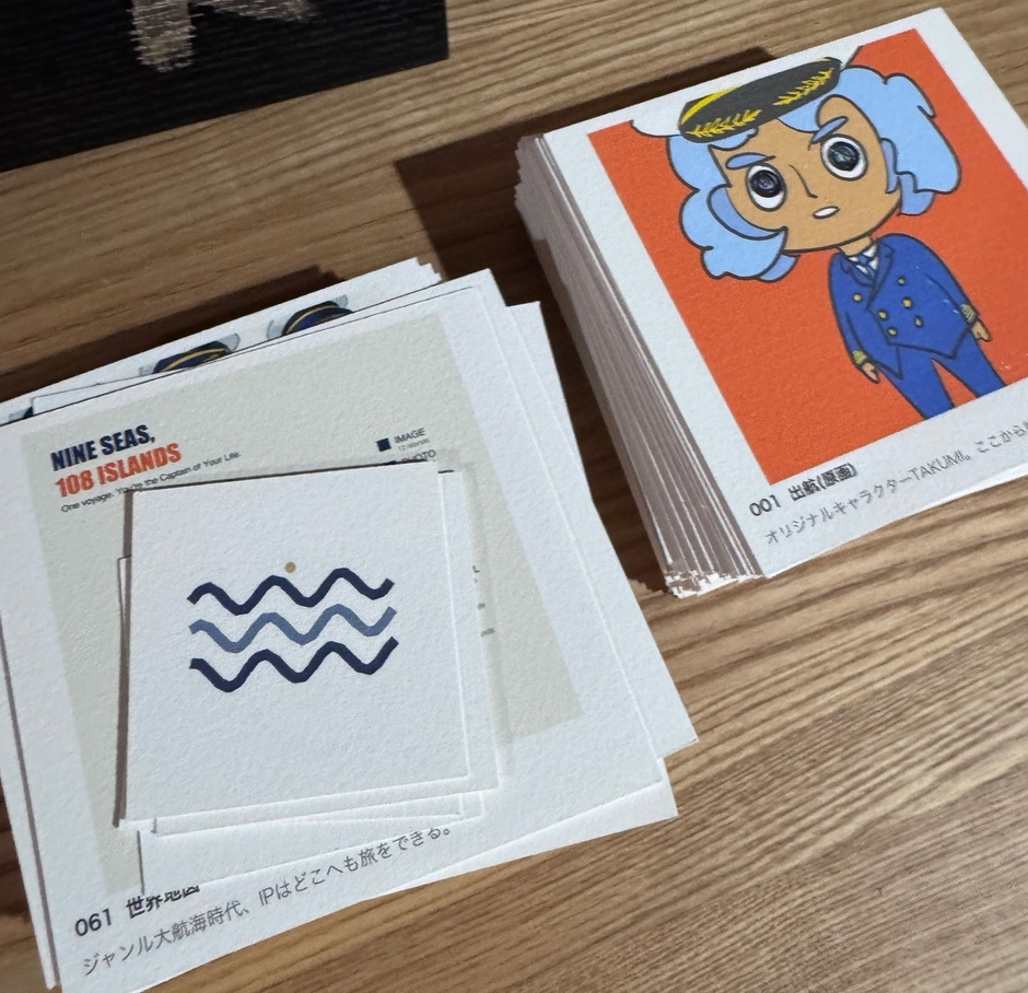 手描きの船長「TAKUMI」と、AIとの対話から生まれた108枚。すべて9cm角のカードとして切り出した