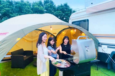 キャンピングカーの前でグランピングBBQを楽しむ