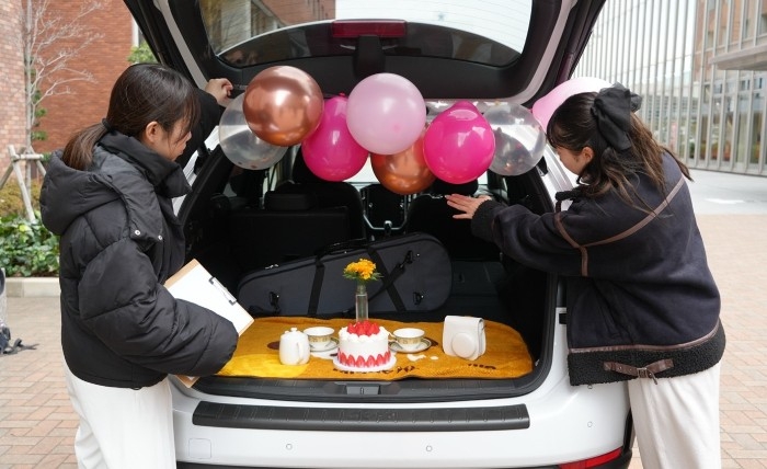 学生が車のトランクをデコる様子