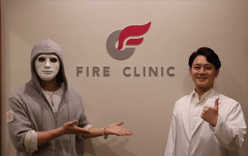 クリニックのロゴの前で写真