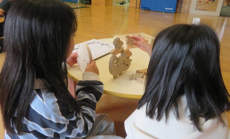 慎重に恐竜ブロックを積み上げていく子どもたち