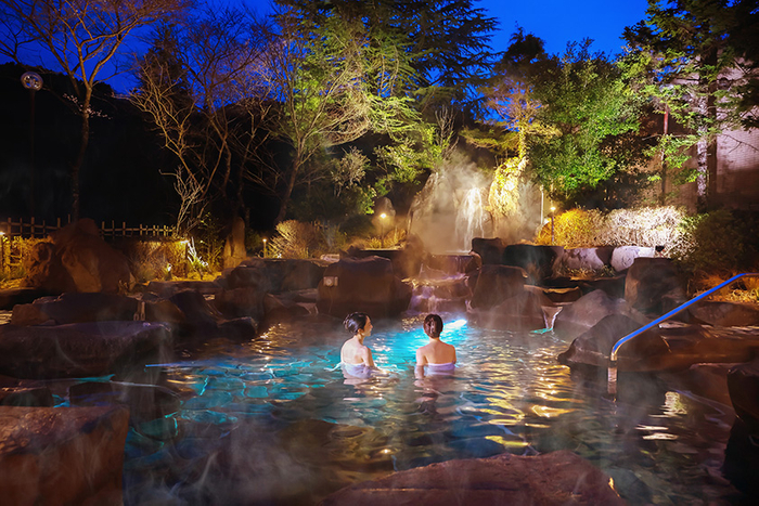 水中照明が幻想的な雰囲気を醸し出す夜の露天風呂。