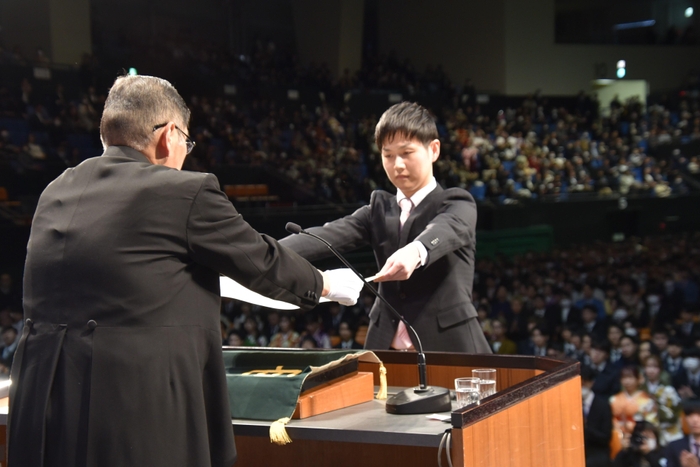 博士課程修了生を代表して学位記を渡される法学研究科の石山皇太さん