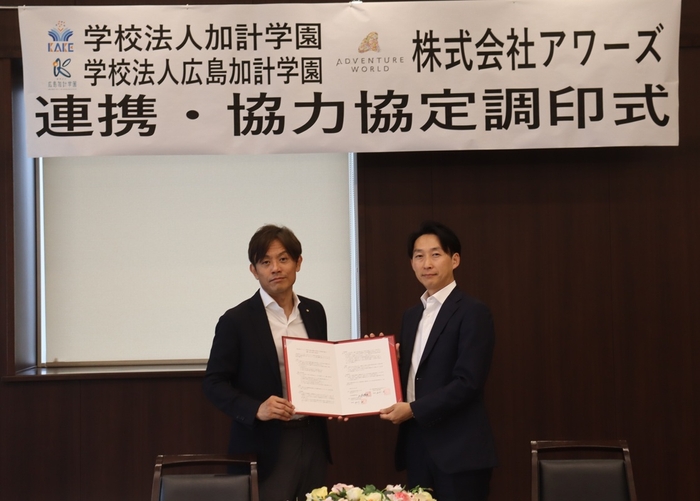 協定書を二人で持つ(左から)加計理事長、山本社長