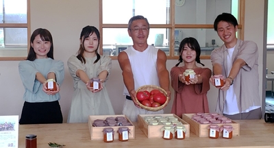 オリジナルトマトソースを手にする学生と曽爾村農家の寺前 健史さん