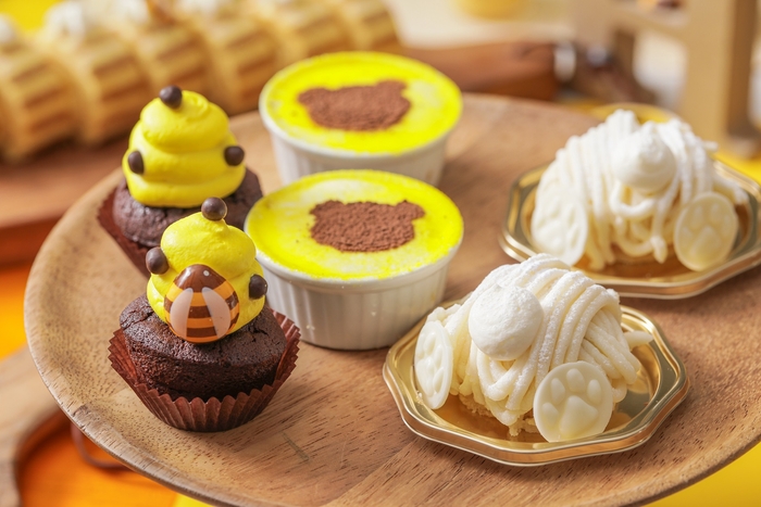 (左)チョコチップマフィン:はちの巣をイメージしたチョコチップの食感を楽しめるマフィン。 (中)くまさんスタンプのティラミス :チーズの濃厚な味わいとほろ苦いコーヒー味が程よいティラミス。 (右)しろくまモンブラン:白あんのクリームと、かのこ豆を合わせ和テイストのモンブランは白熊のお尻に見立て可愛らしい仕上げに。