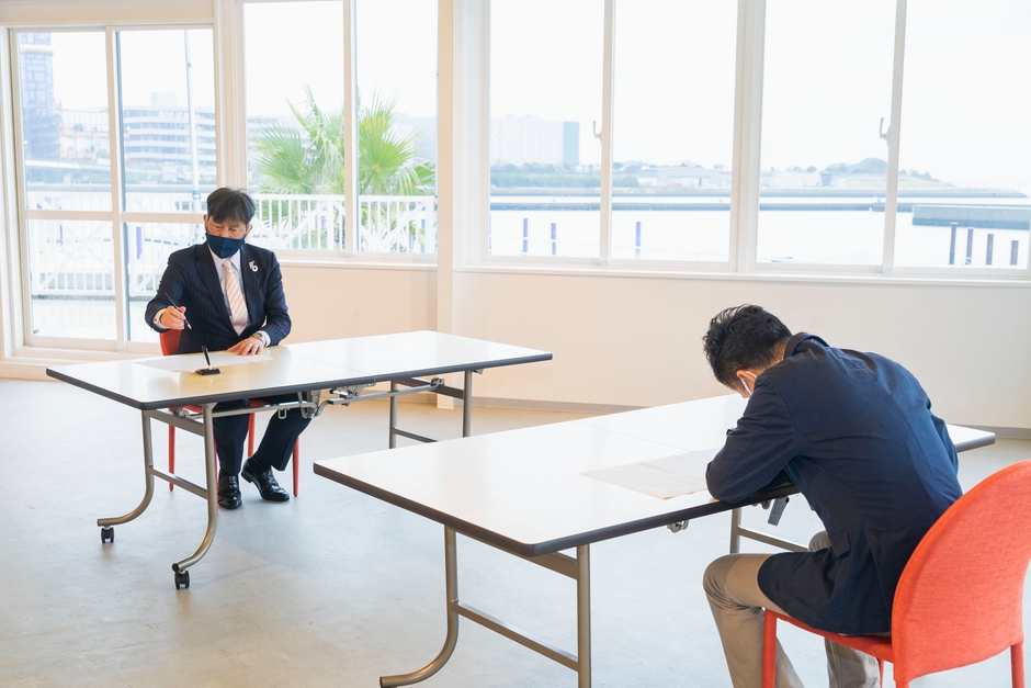 包括連携協定書に署名する高橋此花区長(左)と松尾代表取締役(右)