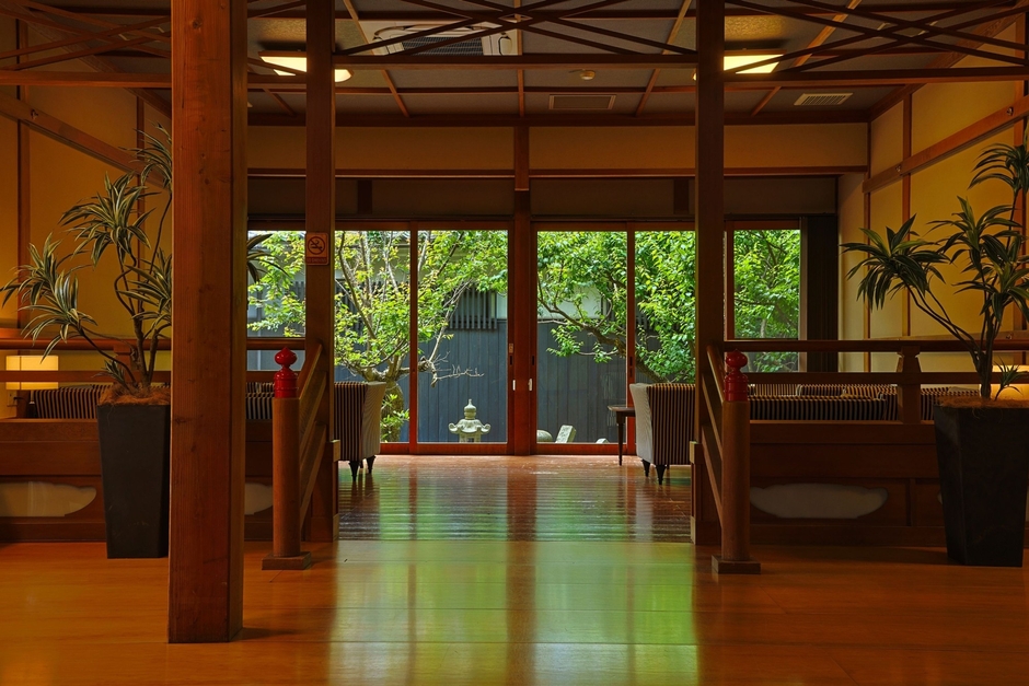 木のぬくもりと静寂に包まれるロビー。中庭では、青梅の瑞々しい緑が初夏の訪れを静かに彩ります