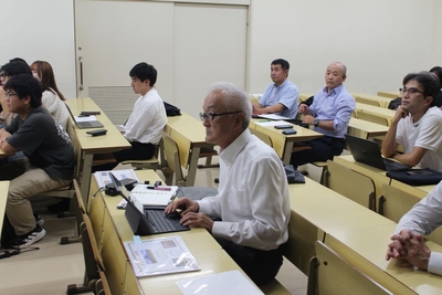 学生たちの報告に聞き入る宮下客員教授（中央）ら