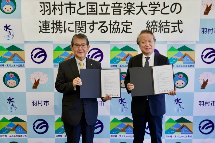 締結式にて 羽村市長:橋本 弘山(左)、学長:武田 忠善(右)