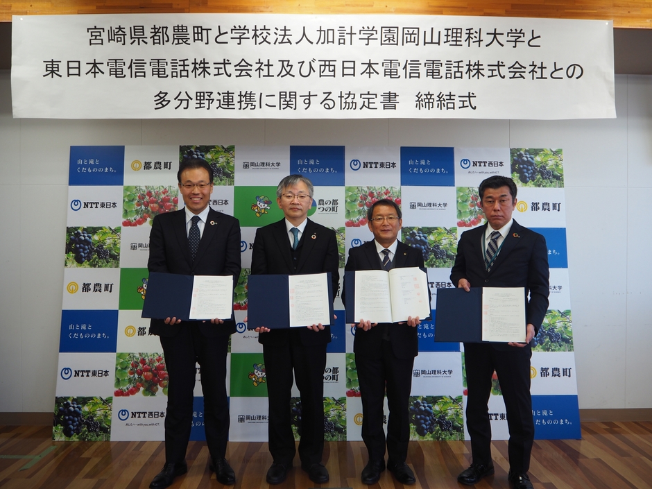協定書を手にする(左から)NTT東日本の小林・産学官連携担当部長、平野学長、河野町長、NTT西日本の古嶋・宮崎支店ビジネス営業部副本部長=都農町の一の宮交流館で