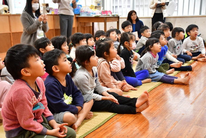 絵本を見つめる三和保育園の園児たち