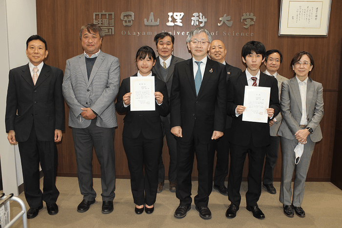 箱崎さんと福田さんを囲み、表彰式の出席者で記念撮影