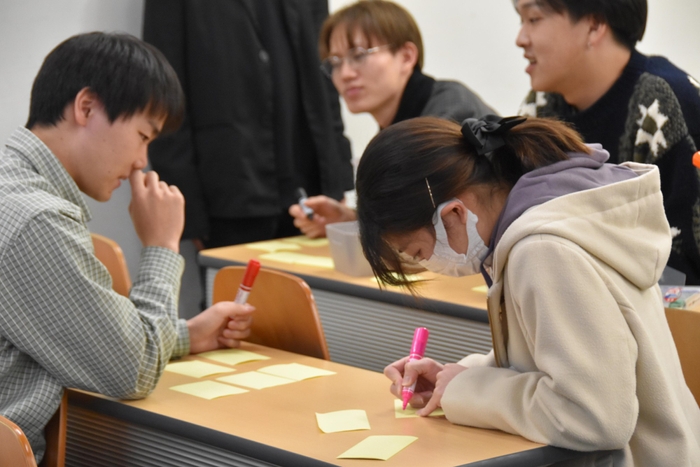 個人ワークでアイデアを出し合う学生たち