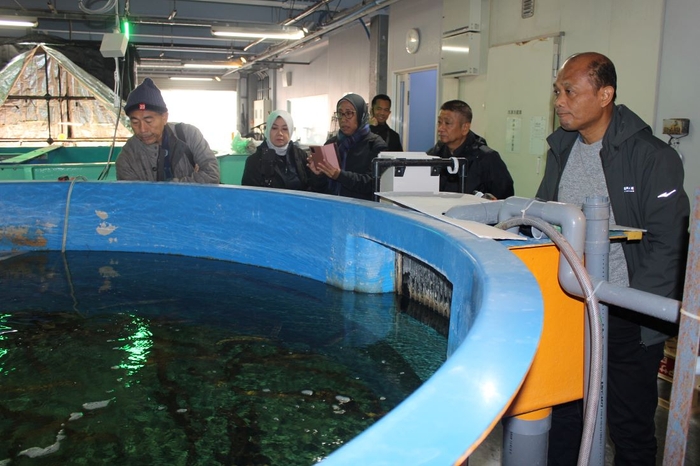 ニホンウナギの養殖水槽を視察するハエル局長（右端）