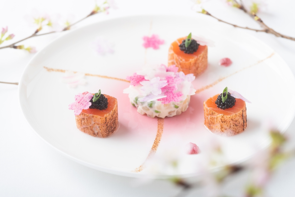 「MENU SAKURA」より前菜の「炙りスモークサーモンとキャビア 根セロリとグリンピース 桜舞うコポーとコンディモン」