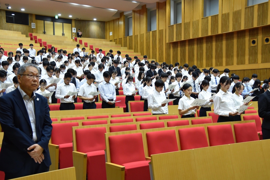 学歌を斉唱する出席者