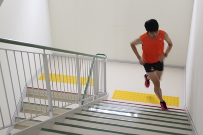 11階建て理大A1号館を駆け上がる吉井さん