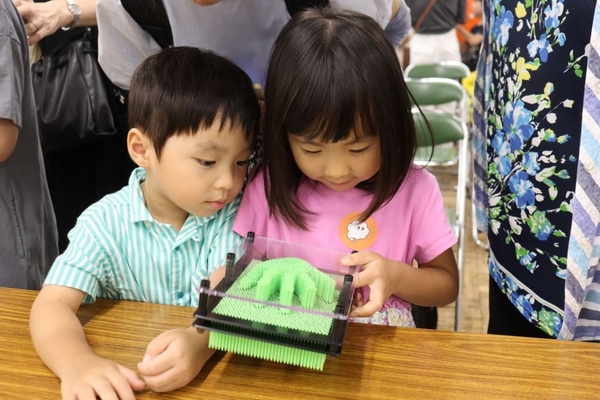 多数のピンを押し上げて出来た立体アートに見入る子どもたち