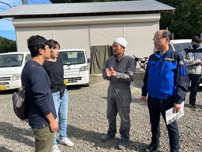 谷内支部長（右）と川原社長（右から２人目）から事情を聴くメンバー