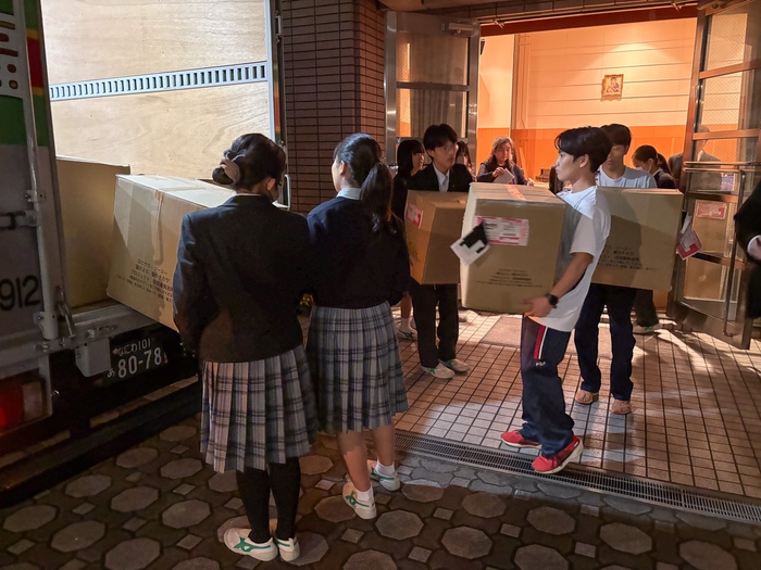 トラックに段ボールを積み込む生徒たち
