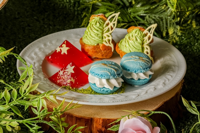 ▲【スタンド中段】妖精の帽子から着想した三角の形のザクロのジュレや、ピスタチオとカスタードクリーム2層の妖精シュークリーム、 ホワイトチョコレートのクリームをたっぷり挟んだマカロン