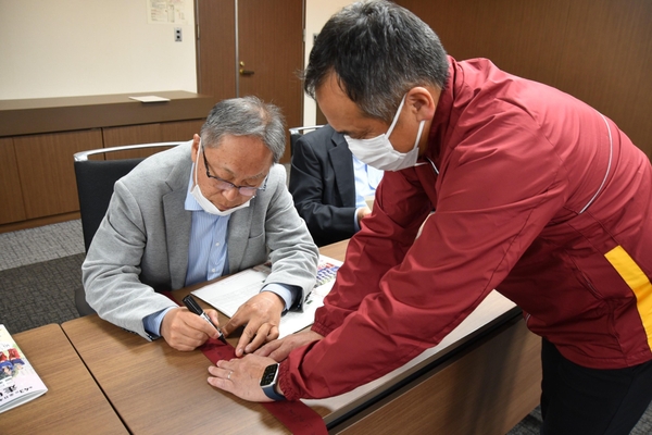 メッセージを書き入れる野口学長
