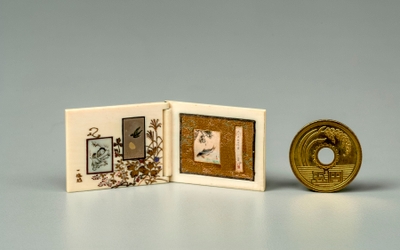 Photo.08-1 つとひ(展開) 2.53×6.23cm マンモスの牙で作られた豆本仕立ての小屏風。絵画、彫金、象牙彫刻、蒔絵など、礫斎のミニチュア制作の協力者たちの技術と名前が勢揃いした作品。