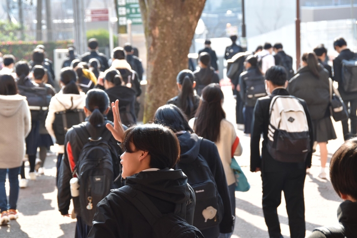 試験を終え、ホッとした表情で友人らと帰る受験生