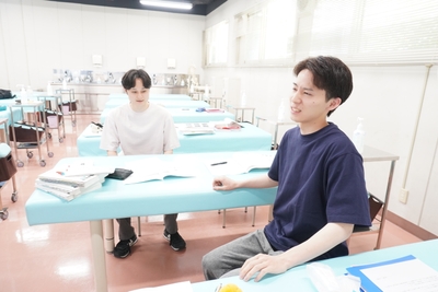 座ったときの不快感に顔をゆがめる学生