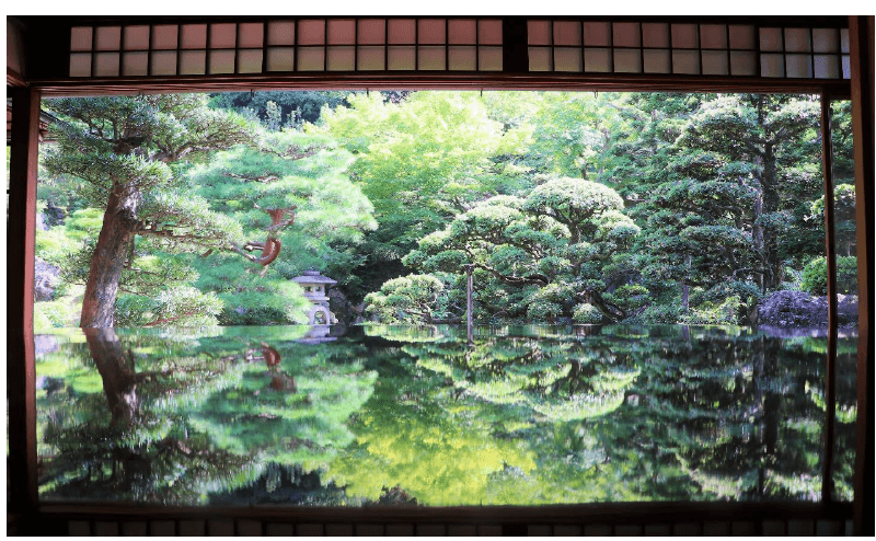 旧邸御室の大広間から眺める庭園。テーブルに写り込んだ木々の緑(2020年撮影)