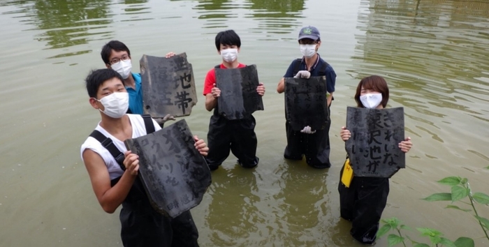 墨書きした古瓦を設置する様子(令和2年実施)