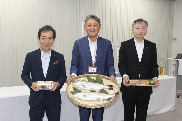 成長したベニザケ、刺身、寿司を手にする（左から）澁谷社長、伊藤社長、平野学長＝福島市の「いちい」本社で7月20日