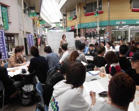 商店街でミニ講義を受ける学生たち