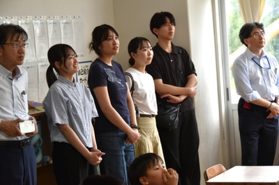 授業の様子を見守る学生と人間学部の笠井尚学部長（右）