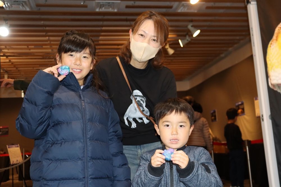 完成したアンモナイトの化石レプリカを手に笑顔の子どもたち