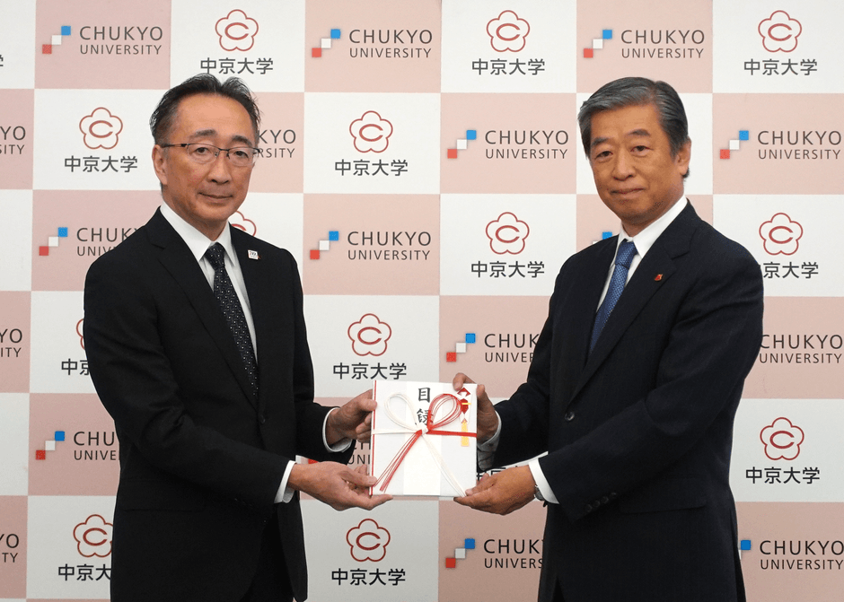 寄贈式の様子(左:中京大学 経営学部長 佐藤 祐司 様、右:当社専務取締役 杉浦 潤一)