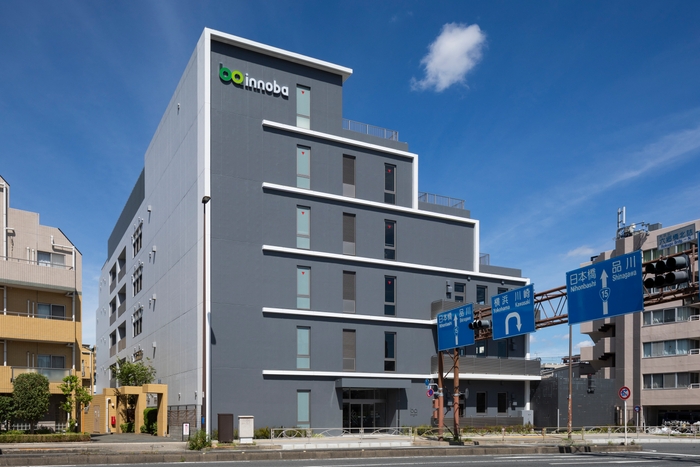 innoba大田の外観。京浜急行本線六郷土手駅徒歩約6分・雑色駅徒歩10分、第一京浜沿いに立地。駐車場は16台。innobaは「innovation(イノベーション」と「場所」を表す「ba」を組み合わせた造語